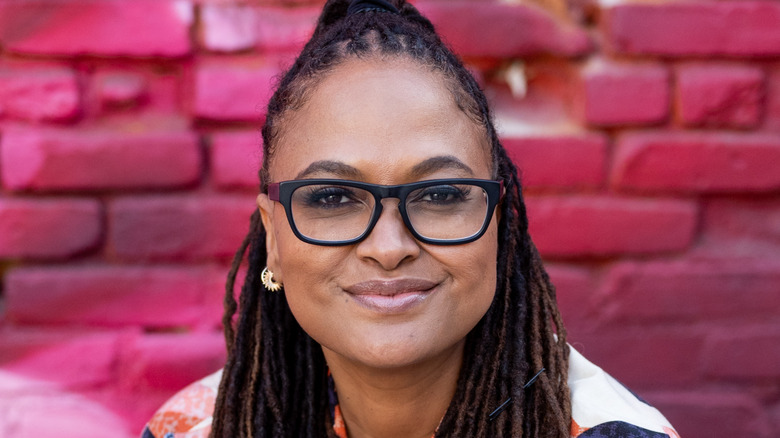 Ava DuVernay in front of a pink brick wall