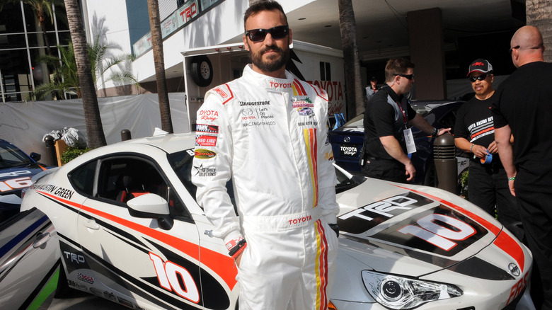 Brian Austin Green standing next to a race car