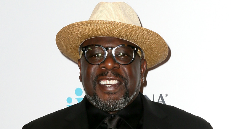 Cedric the Entertainer smiling, wearing straw hat