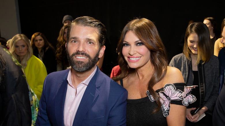 Donald Trump Jr. and Kimberly Guilfoyle seated and smiling