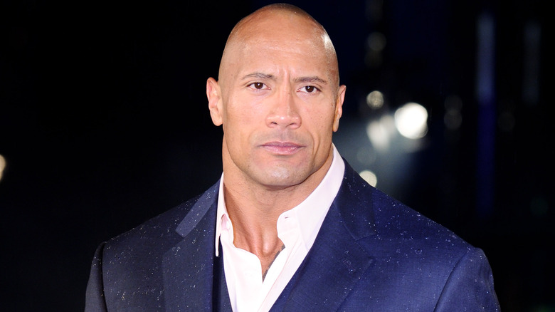 Dwayne Johnson looking serious in blue suit