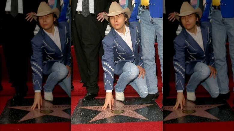 Dwight Yoakam kneeling