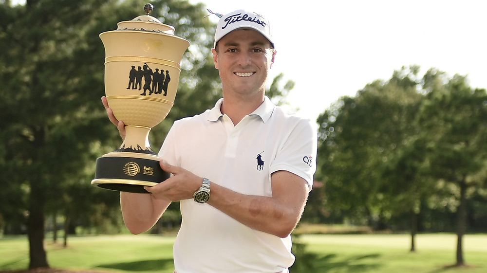 Justin Thomas holding a big award 