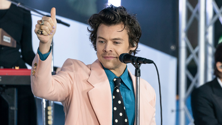 Harry Styles giving thumbs up on stage