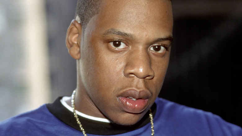 Jay-Z wearing a blue shirt and chain