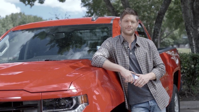 Jensen Ackles leaning against a car, posing