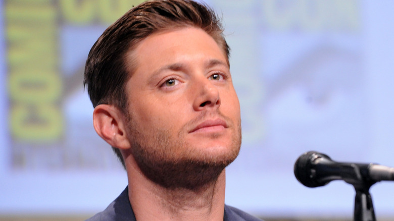 Jensen Ackles seated and gazing off