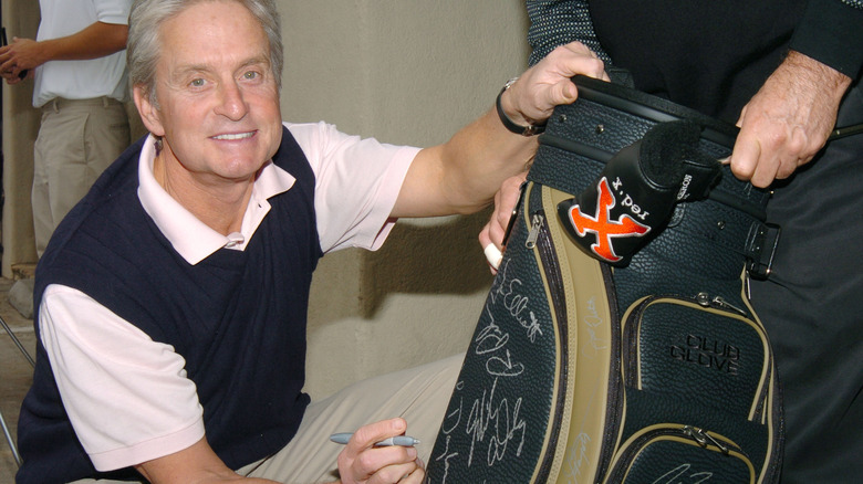 Michael Douglas autographing charity golf bag