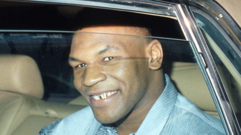 Mike Tyson inside of a car, smiling