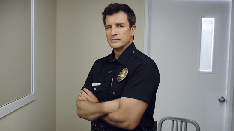 Nathan Fillion posing in an officer's uniform