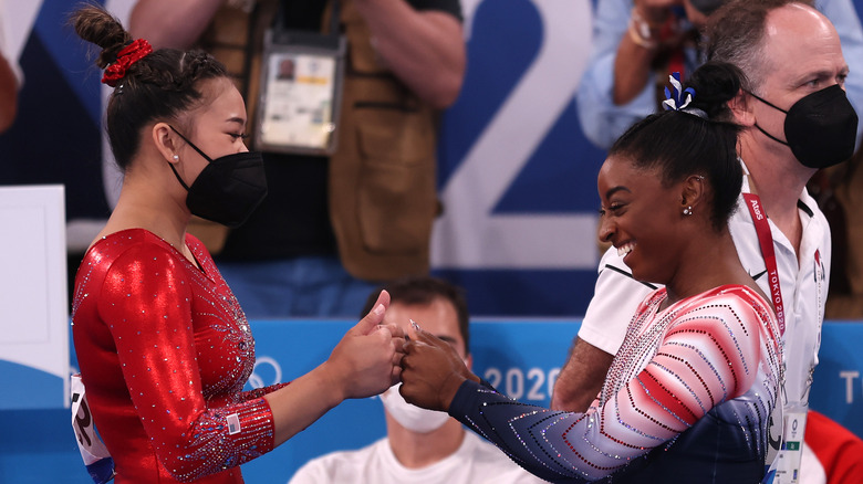 Suni Lee and Simone Biles congratulating one another