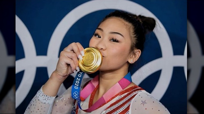 Suni Lee kissing her gold medal