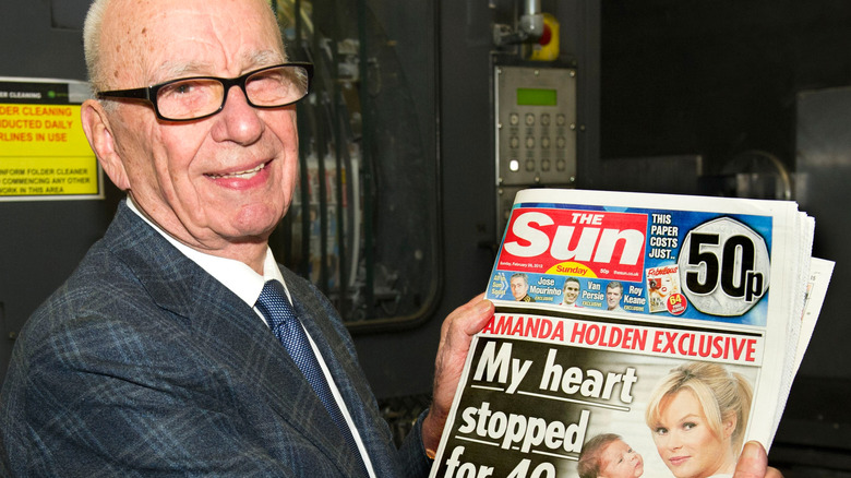 Rupert Murdoch posing with The Sun newspaper in hands