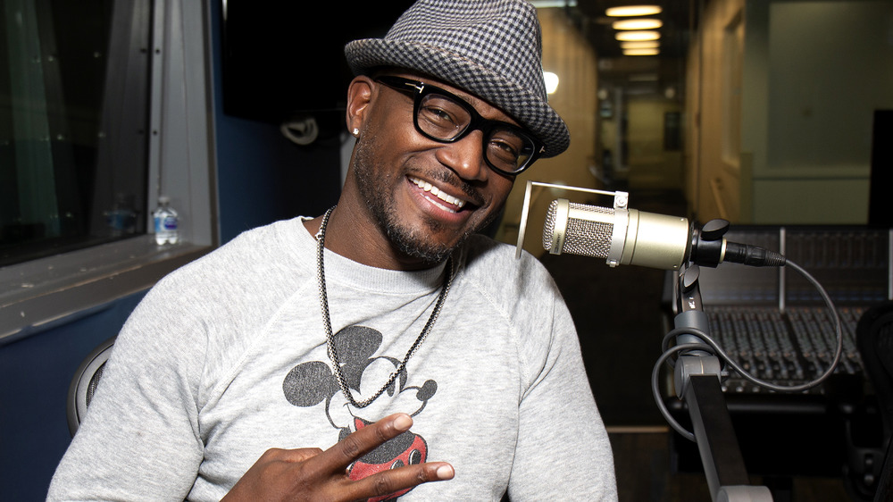 Taye Diggs smiling alongside a microphone