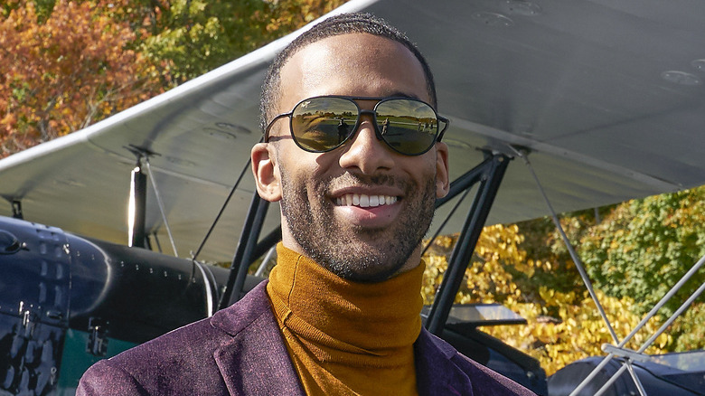 Matt James standing in front of a plane