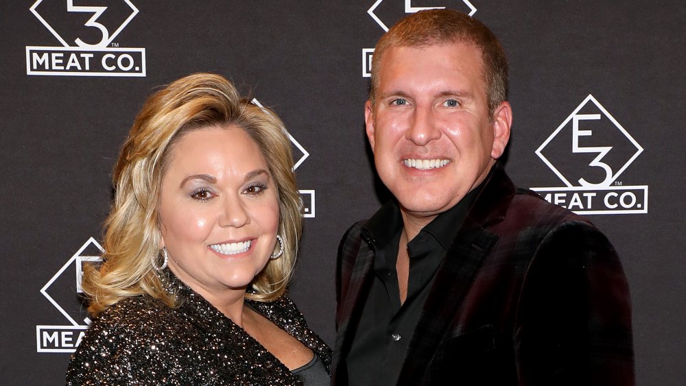 Julie Chrisley, Todd Chrisley smiling and posing next to each other at an event