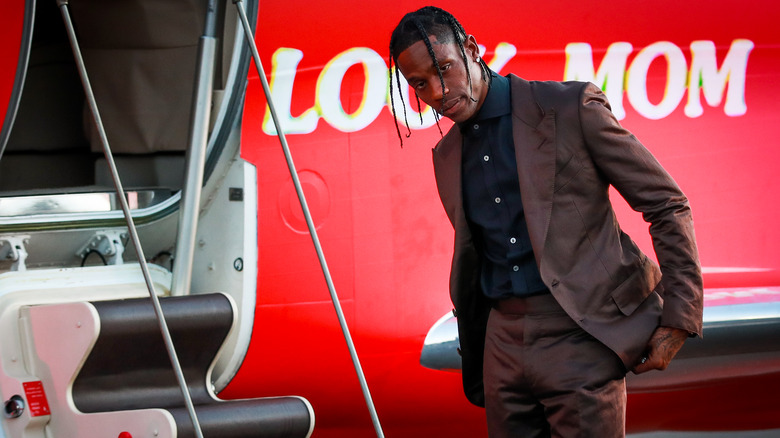 Travis Scott in front of a plane