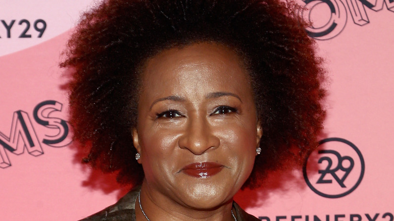 Wanda Sykes standing in front of a pink wall