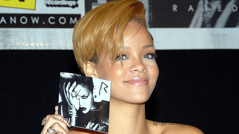 Rihanna holding her "Rated R" album 