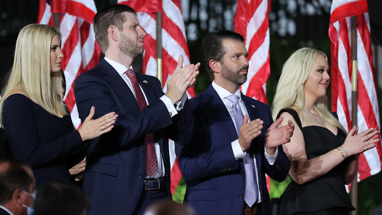 Ivanka Trump, Eric Trump, Donald Trump Jr., and Tiffany Trump stand in front of flags