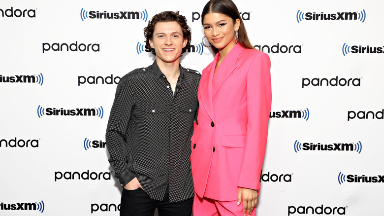 Tom Holland and Zendaya smiling and posing