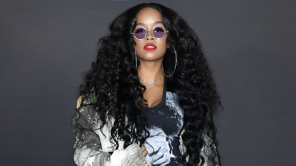 H.E.R. poses for cameras wearing tinted glasses