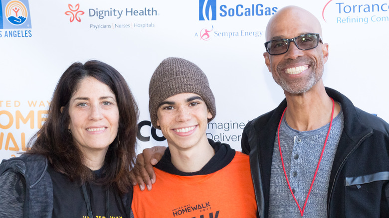 Cameron Boyce and his parents, smiling