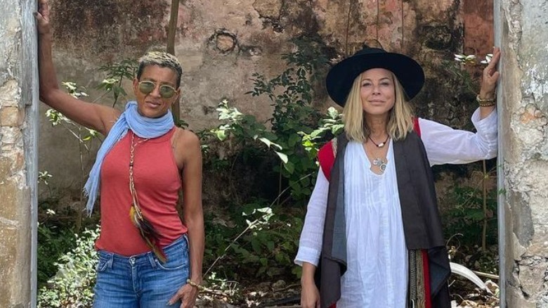 Maria Bello and Dominique Crenn standing with their arms raised