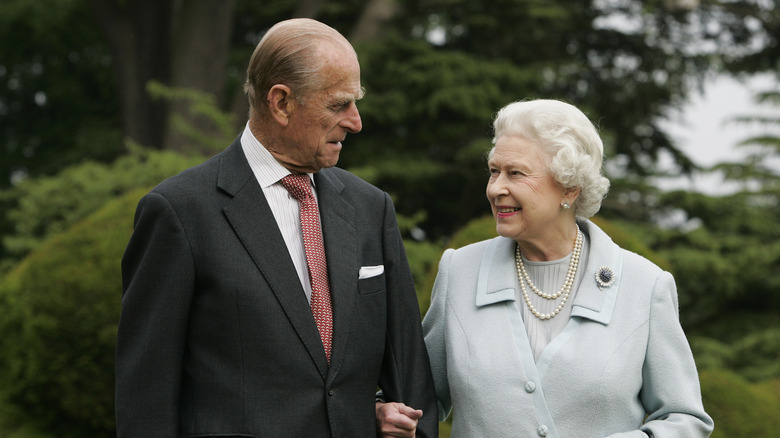 Queen Elizabeth II and Prince Philip linking arms