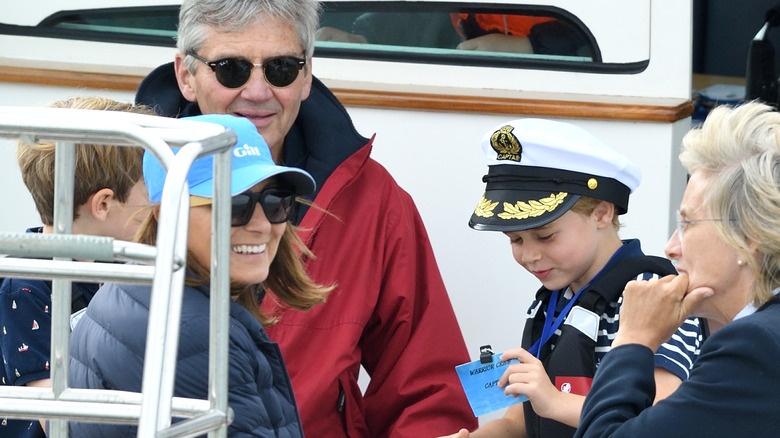 Carole and Michael Middleton sitting with Prince George