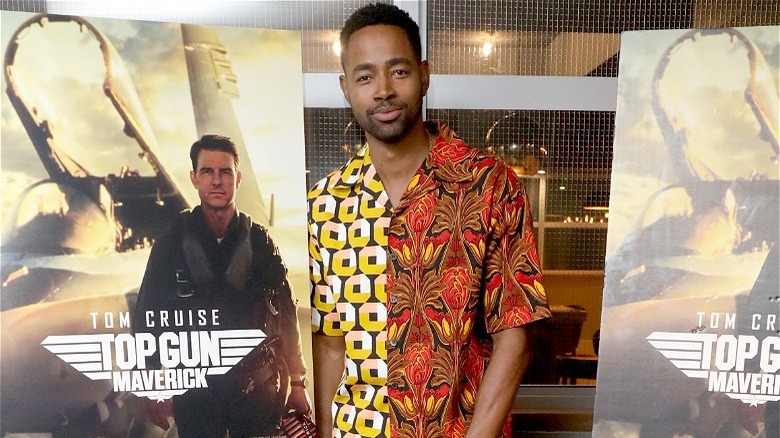 Jay Ellis poses with Top Gun: Maverick posters