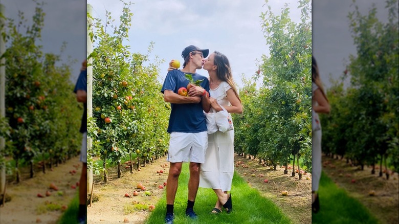 Tolya Ashe, Rachel Boston kissing in orchard