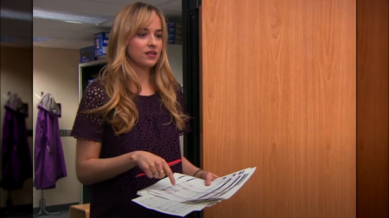 Dakota Johnson holding documents