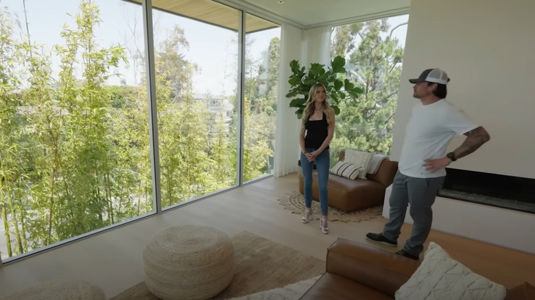 Christina Hall standing bug a large window in her home with someone stand nearby.