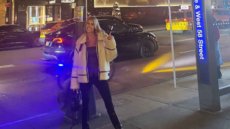 Christina Hall posing on the streets of New York City in a white jacket