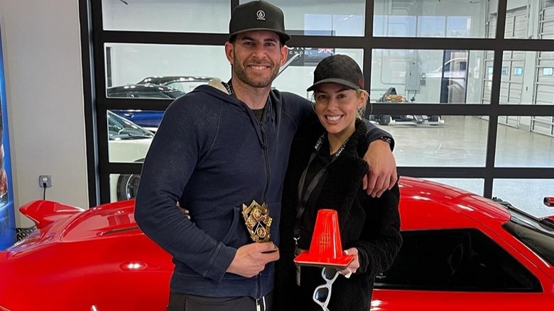 Tarek El Moussa and wife Heather Rae El Moussa pose for the camera at Radford Racing School