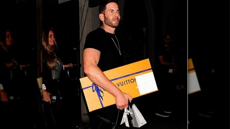 Tarek El Moussa carrying Louis Vuitton and Versace shopping bags