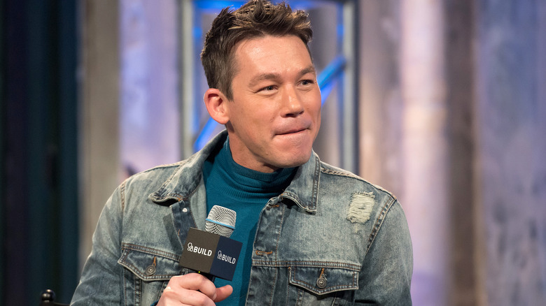 David Bromstad holding a microphone wearing a denim jacket