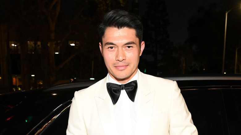 Henry Golding posing in a tuxedo