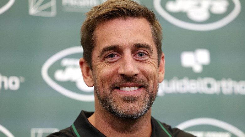 Aaron Rodgers smiling at a New York Jets event.