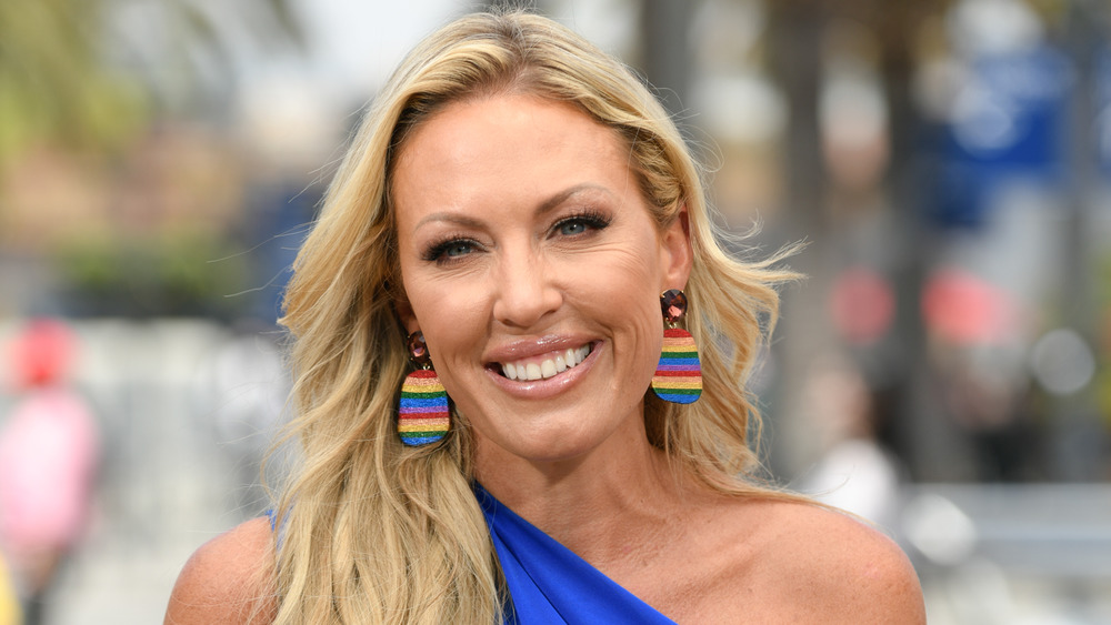 Braunwyn Windham-Burke smiling in rainbow-colored earrings