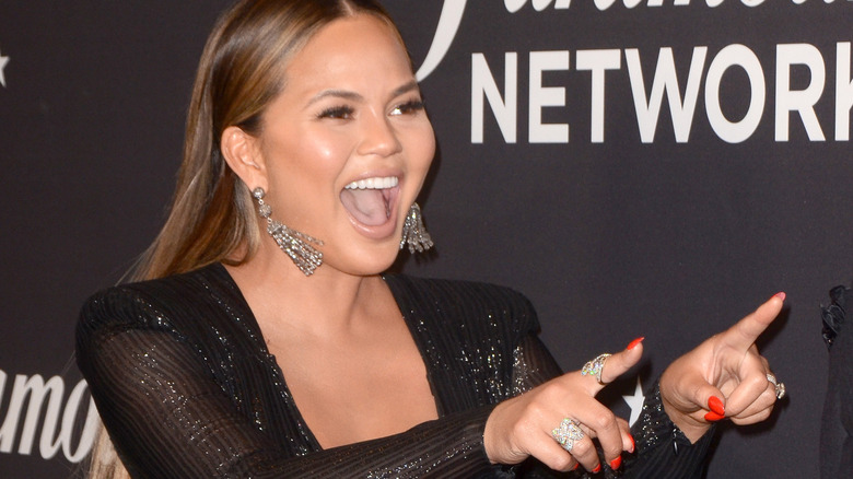 Chrissy Teigen laughing and pointing