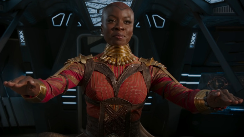 Danai Gurira with raised hands in "Black Panther"