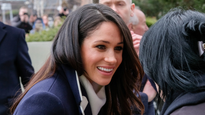 Meghan Markle talking with someone