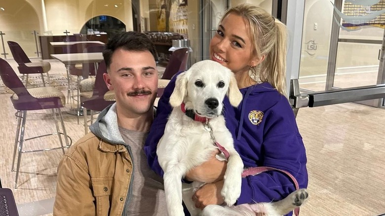 Paul Skenes and Olivia Dunne sit with a dog