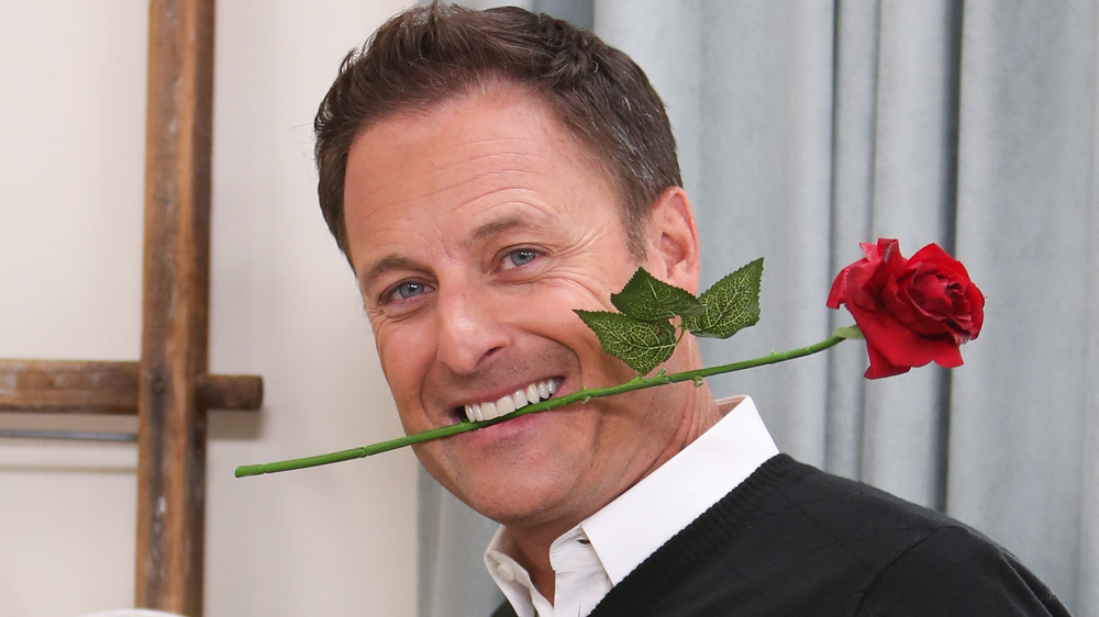 Chris Harrison smiling with a rose in his mouth