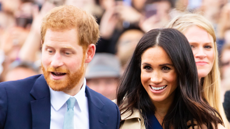 Prince Harry and Meghan Markle smiling at public event in Australia