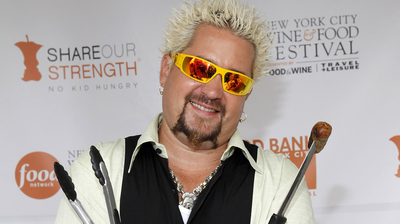 Guy Fieri posing tongs