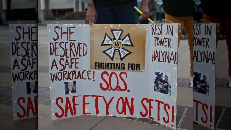 Mourner holds sign calling for better safety on movie sets during vigil honoring Halyna Hutchins