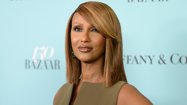 Iman poses in an olive green dress